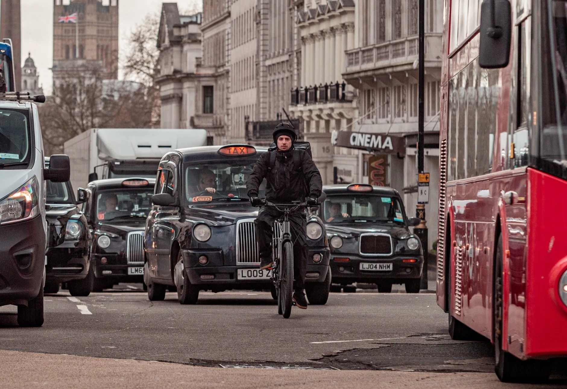 Delivery rider on a Trayser 2.0 between two London black cabs